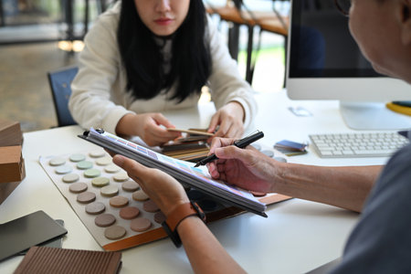 Cropped shot female customer choosing paint color from samples for home interior design.の写真素材