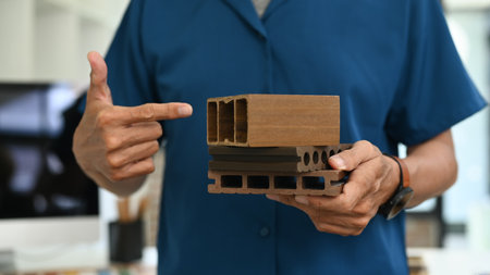 Cropped shot unrecognizable architect holding sample of wooden panel for furniture.の写真素材