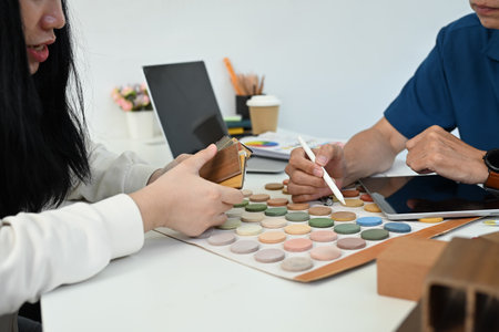 Friendly senior male designer expert helping his client choosing color palette for indoor decor.の写真素材