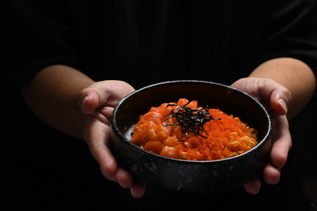 Stir fried spicy udon noodles with fresh salmon, tobiko egg and seaweed on top. Japanese fusion food concept.の写真素材