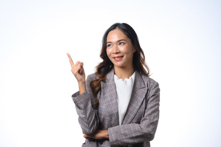 Portrait of beautiful businesswoman executive pointing finger up at copy space on white background.の写真素材