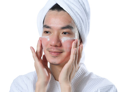 Man applying moisturizing and anti aging cream on his face after shower. Skin care and cosmetic procedures concept.の写真素材