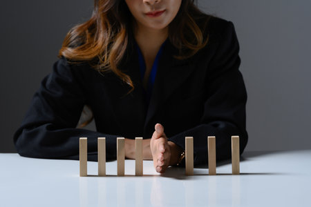 Professional businesswoman hand between upright wooden blocks Concept of business risk management.の写真素材