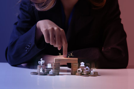 Businesswoman in black suit with stack of coins. Income Management and saving money concepts.の写真素材