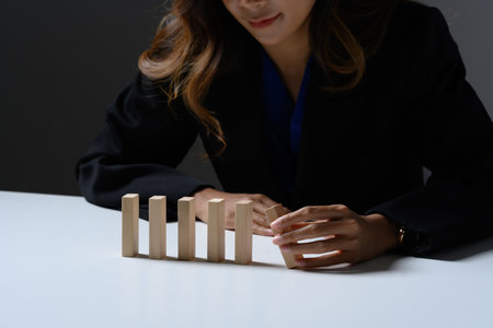 Professional businesswoman arranging wooden blocks. in a row. Concept of business risk management.の写真素材