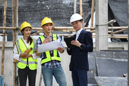 Structural engineers team and businessman planning development details about project at construction site.の写真素材