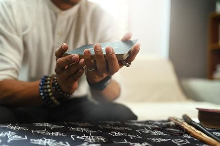 Fortune teller shuffling the tarot cards in his hands. Astrologists, forecasting and divination...