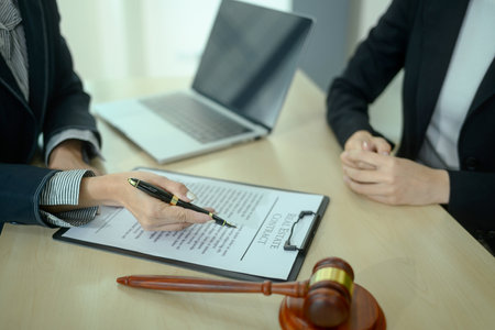 Lawyer consulting a client in office with legal paperwork or home purchase agreement.の写真素材
