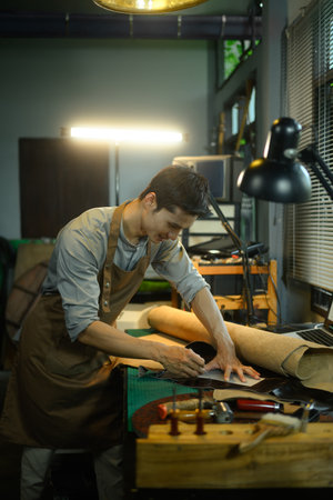Tailor leather craftsman measuring leather for sewing at his workshop.