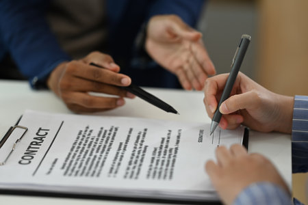 Professional realtor in suit pointing at contract document to client put a signature. Real estate and property insurance concepts.の写真素材