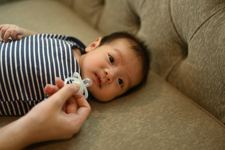 Cropped shot of mother giving pacifier cute little newborn baby. Child care concept.