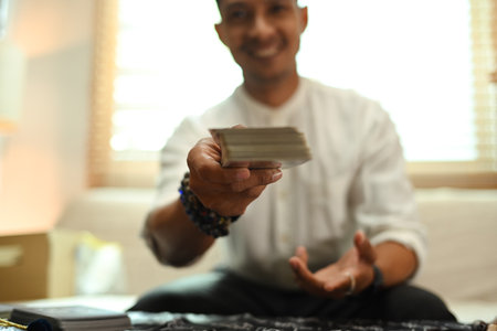 Selective focused on hands of fortune teller holding deck of tarot cards. Forecasting and divination concept.の写真素材