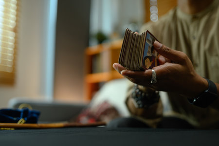Mysterious fortune teller holding deck of tarot cards. Forecasting and divination concept.の写真素材