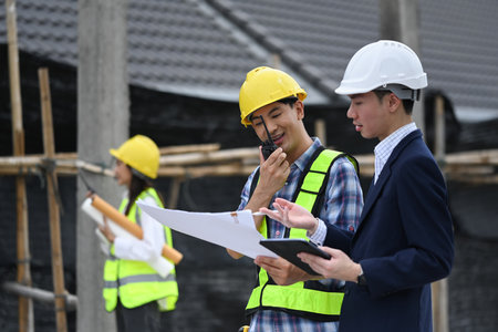 Engineers and businessman planning development details about project at construction siteの写真素材