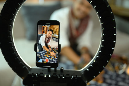 Cheerful man tarot reader doing predicting online and recording video with smartphone.の写真素材