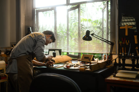 Dedicated craftsman engrossed in his work at a workshop. Small business and Handmade concept.の写真素材