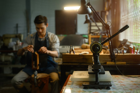 A special press machine on wooden table in a local workshop. Workplace for shoemaker.の写真素材