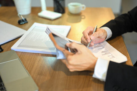 Cropped shot of elderly businessman reviewing statistic graph working on marketing project at...