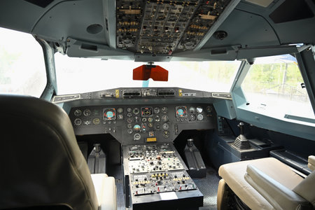 Interior of cockpit of an airplane with control panels, instruments and gauges.
