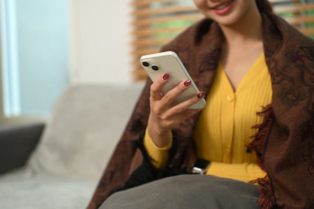 Smiling young woman messaging or browsing social networks on mobile phone.の写真素材