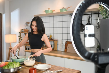 Young fitness woman vlogging about preparing a healthy meal in kitchen. Healthy lifestyle vlogs,...