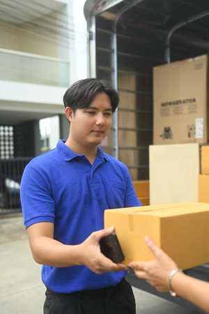 Woman receiving the parcel from delivery man. Shipping, logistics and transportation concept.