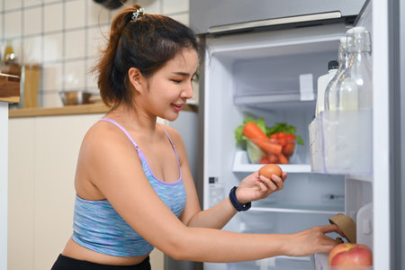 Young woman searching for ingredients while preparing a meal or snack.の写真素材