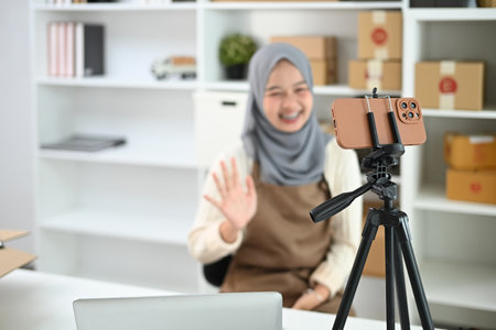 Young Muslim woman with hijab working live streaming to sell products. E-commerce and small business concept.の写真素材