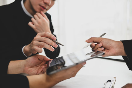 Cropped shot of young businesspeople collaborating on their new project at modern office.の写真素材