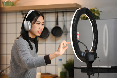 Cheerful young woman dancing and recording a video for social media on smartphone.