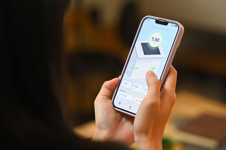 Woman holding a smartphone, displaying an app that monitors solar panel energy usage. Renewable...