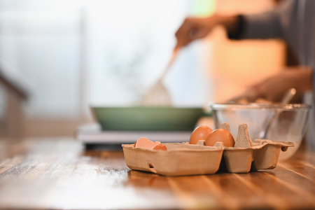 Close up shot of organic eggs in a carton tray on a wooden kitchen counter.
