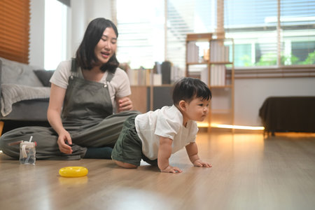 Cute toddler crawling on the floor in brightly living room. Child development and learning concept.
