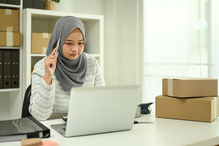 Focused small business owner sitting in home office and looking contemplative.の写真素材