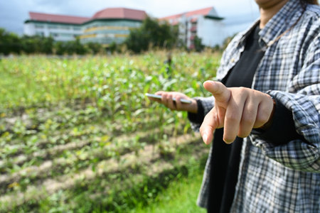 Farmer pointing with finger to the camera or pressing fingers on the virtual touch screen. Smart farming concept.の写真素材