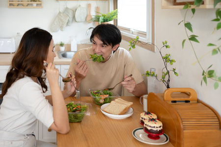 Happy young couple enjoying a healthy meal together in a minimalist kitchen.の写真素材