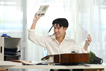 Frustrated male employee smashing calculator in stressful moment.の写真素材