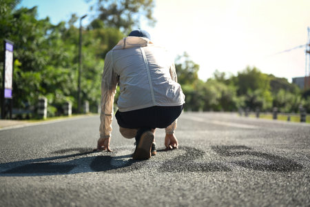 Ready to sprint into 2025, New Goals. Male runner in starting position on road.