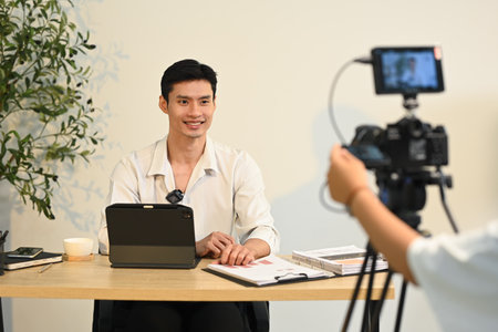Successful young entrepreneur speaking on camera during office interview.