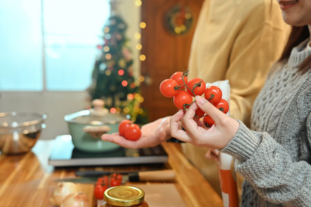 Close up of young woman choosing fresh tomatoes for a holiday dish.の写真素材