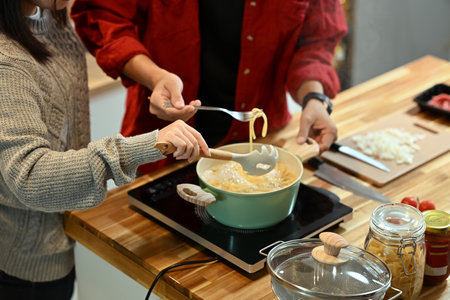 Young married couple making pasta together during the festive season.の写真素材