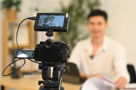 Close up of camera displaying professional businessman during on camera interview.