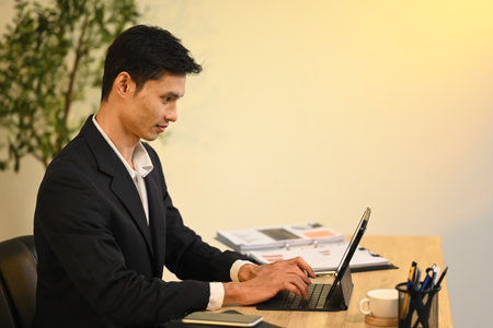 Focused professional businessman working on important project with digital tablet at office.