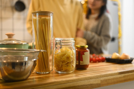 Pasta, sauce and fresh ingredients on kitchen counter for a delicious pasta meal.の写真素材