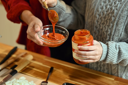 Cropped shot woman preparing a warm pasta dish for festive meal in kitchen.の写真素材