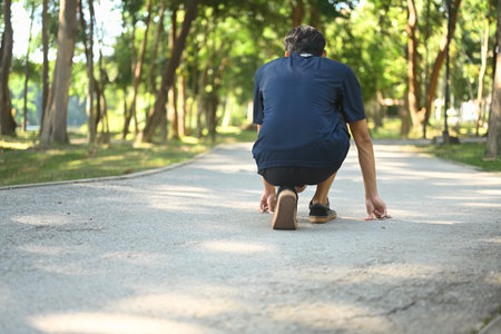 Back view of man in a starting position on the ground, ready to sprint. Goals and motivation...