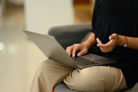 Cropped shot young woman speaking during video call on her laptop at home.の写真素材
