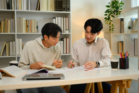 Tutor helping student man with academic tasks. Education and tutoring concept.の写真素材