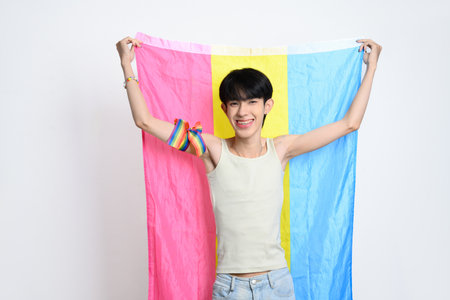 Cute Asian homosexual men holding up pansexual pride flag over white background. LGBTQ pride and equality concept.の写真素材
