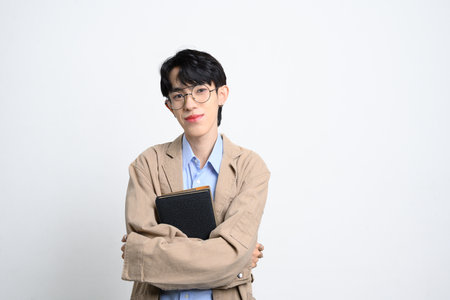 Confident young entrepreneur wearing glasses standing on white background. Startups and career growth concept.の写真素材